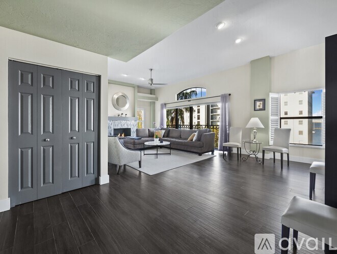 A modern living room with a grey sofa and a glass coffee table.