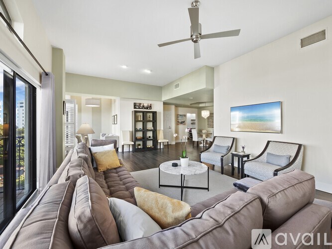 A living room with a brown couch and a ceiling fan.