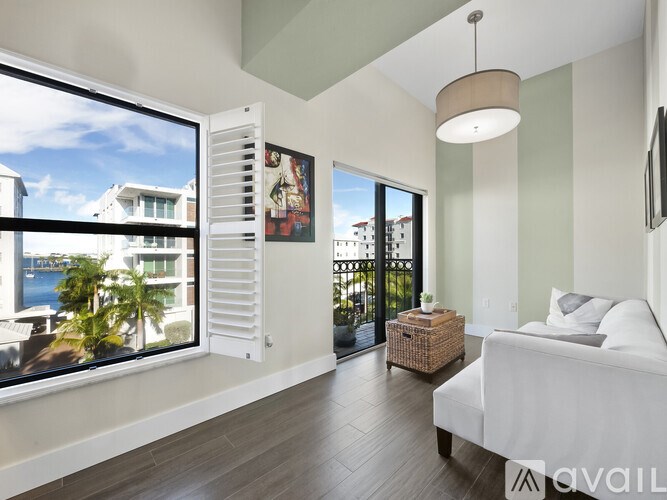 A bedroom with a large window overlooking a waterfront.