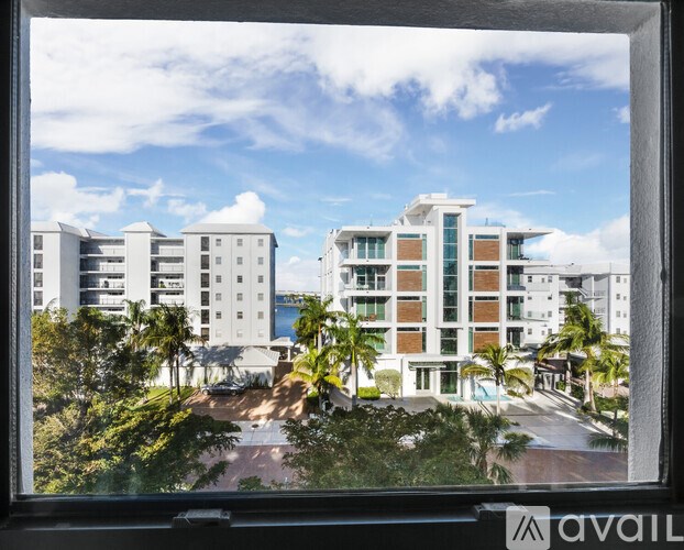 A view of a residential area with buildings and palm trees.