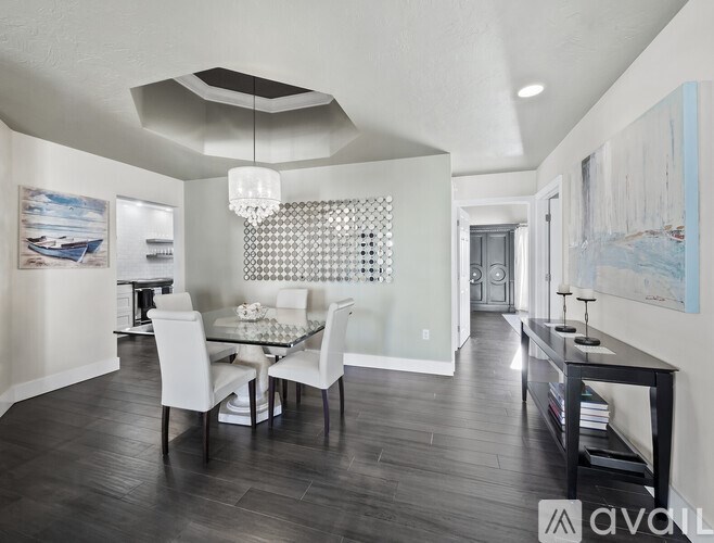 A modern dining room with a glass table and chairs.