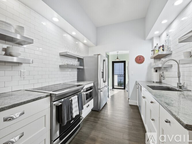 A modern kitchen with white cabinets and a marble countertop.