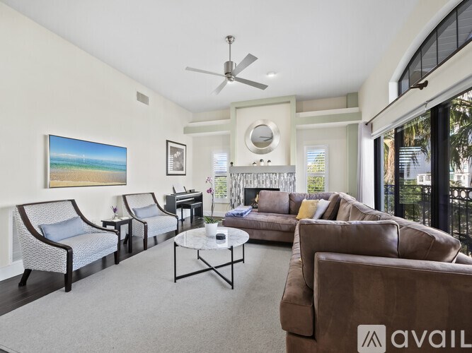 A living room with a painting of a beach scene on the wall.