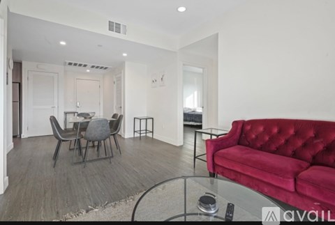 A living room with a red couch and a glass coffee table.