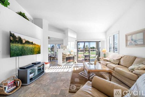 A living room with a flat screen TV on the left side and a couch on the right side.