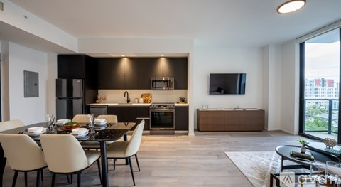 A modern dining room with a black table and white chairs.