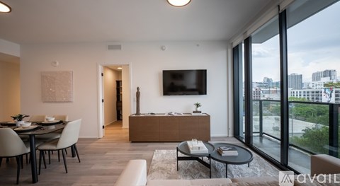 A modern living room with a view of the cityscape outside the large windows.