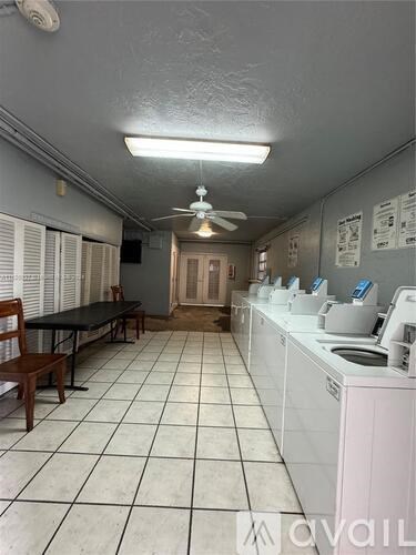 A laundromat with washers and dryers lined up on the right.