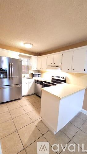 A kitchen with a white island in the middle.