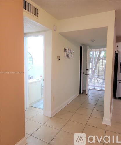A kitchen area with a refrigerator and a dining table.