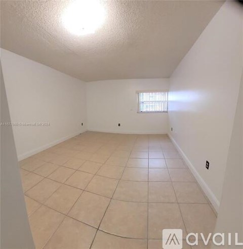 A room with a window and tiled floor.