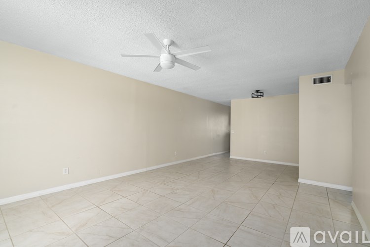 A room with a ceiling fan and tile flooring.