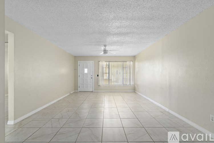 A room with a door and a window with blinds.