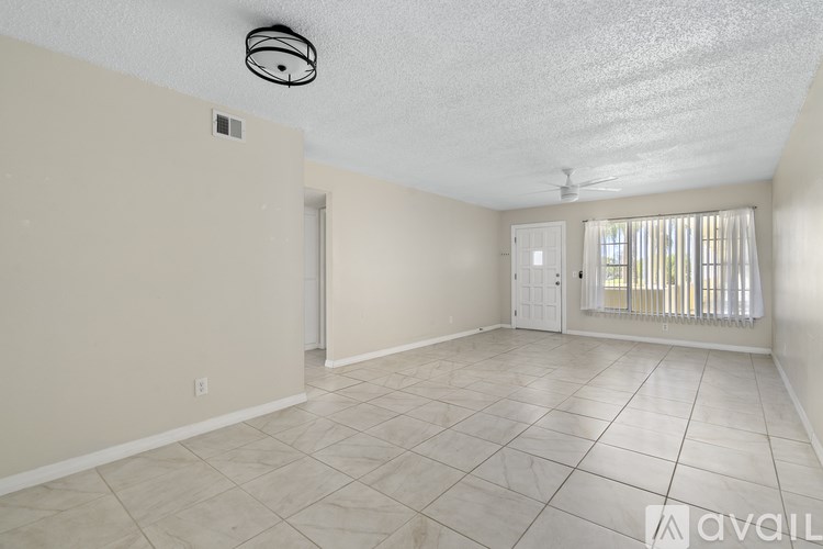 A room with beige walls and a tiled floor is available for rent.