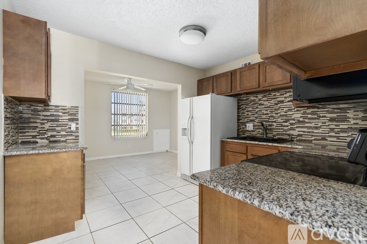 A kitchen with wooden cabinets and a granite countertop.