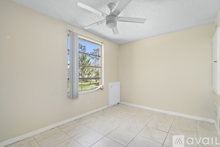 A room with a ceiling fan and a window.