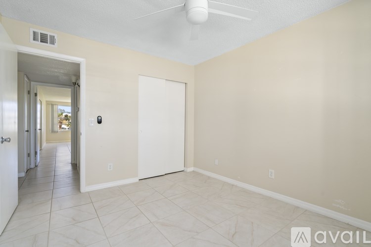 A room with a white door and a ceiling fan.