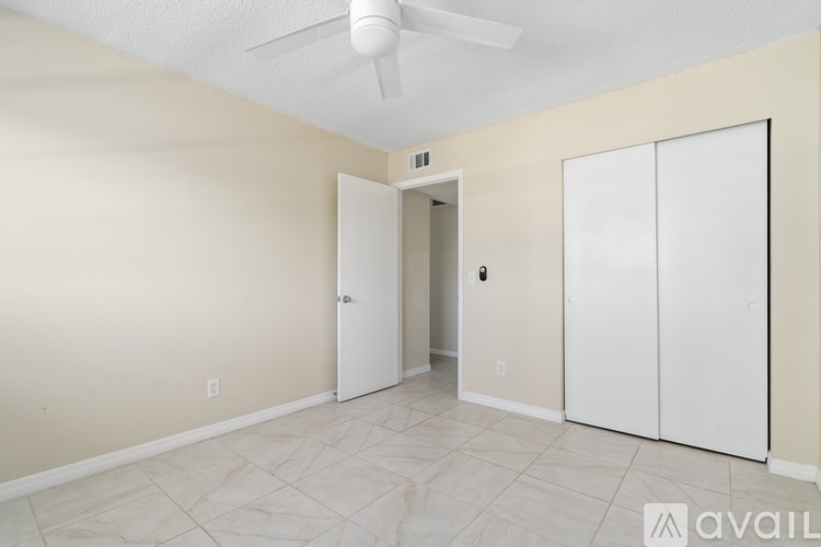 A room with a fan, two doors, and a cabinet.