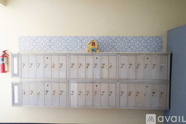 A wall of filing cabinets with a blue patterned wallpaper above them.