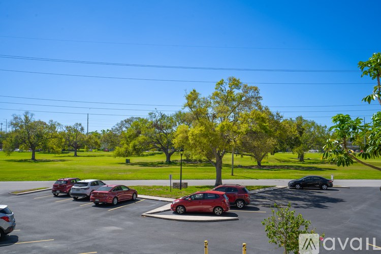 A parking lot with cars and trees in the background.