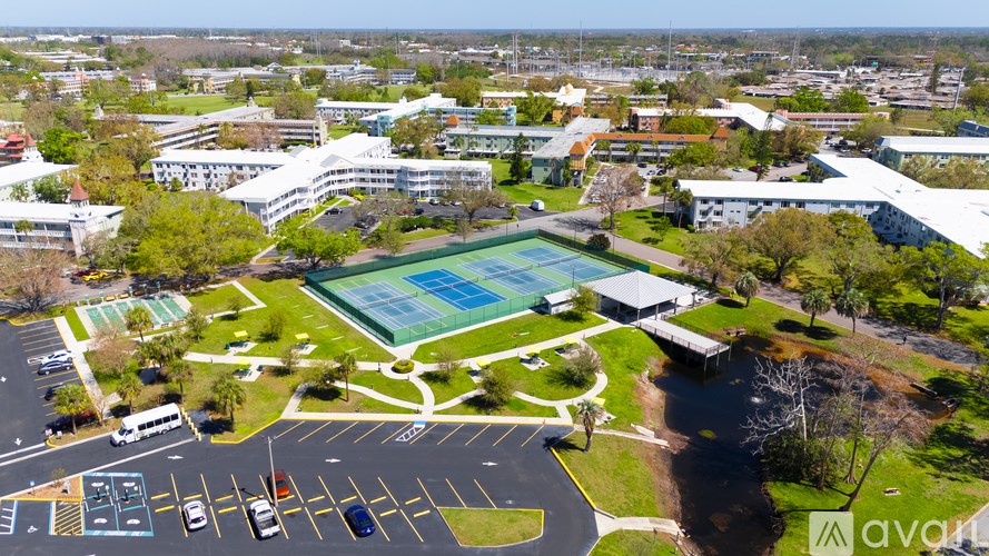 An aerial view of a school with a swimming pool and a parking lot.