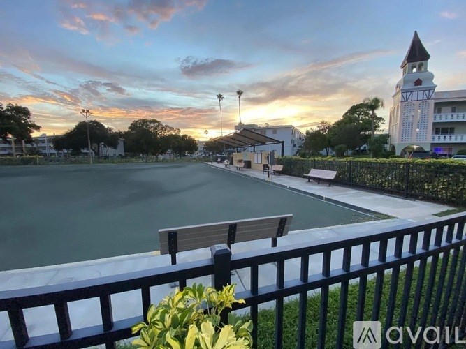 A pool surrounded by a fence with a sunset in the background.
