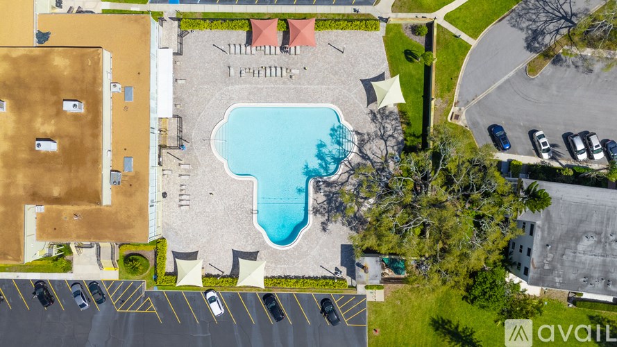 An aerial view of a parking lot with a swimming pool.