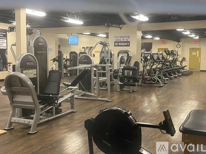 A gym with a variety of equipment including treadmills, weights, and exercise machines.