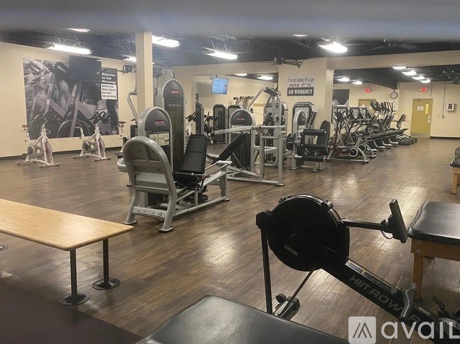 A gym with a variety of equipment including weights and cardio machines.