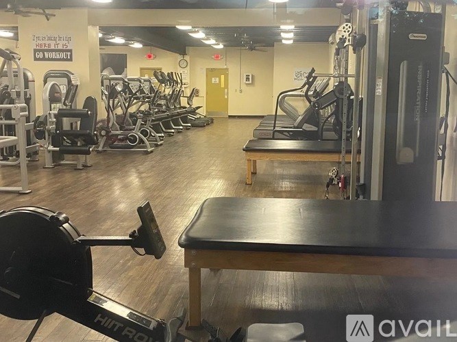 A gym with a variety of equipment including treadmills, weights, and exercise machines.