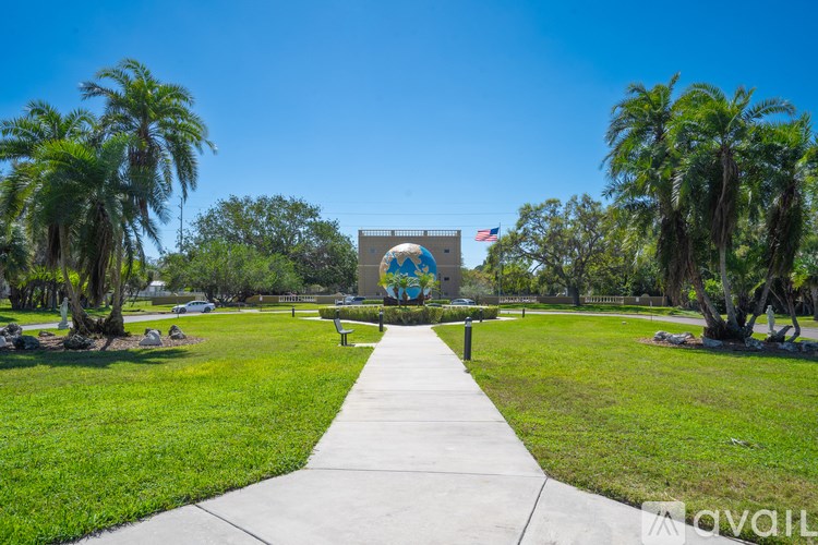 A walkway leads to a building with a sign that reads "AVAILABLE" in front of some trees.