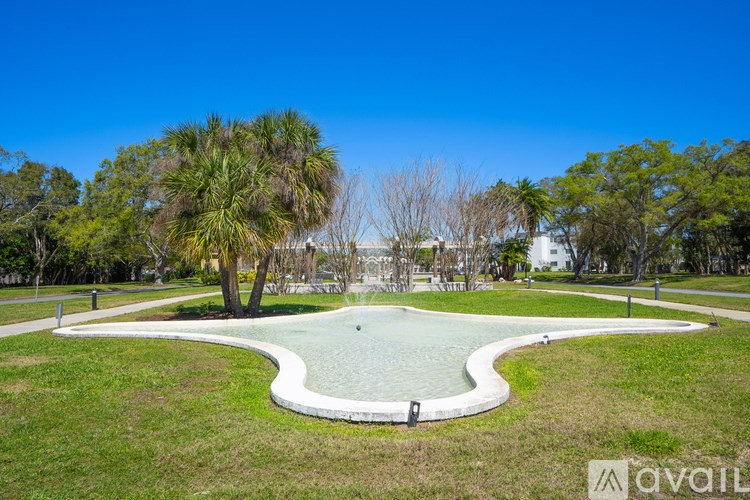 A park with a pond and trees.