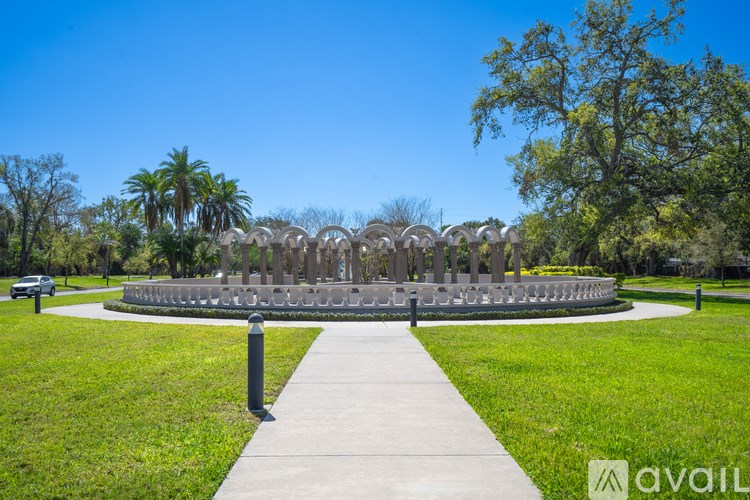 A park with a circular monument and a walkway leading to it.