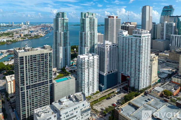 A cityscape with tall buildings and a body of water in the background.