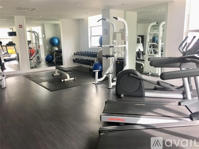 A gym with treadmills, weights, and exercise equipment.