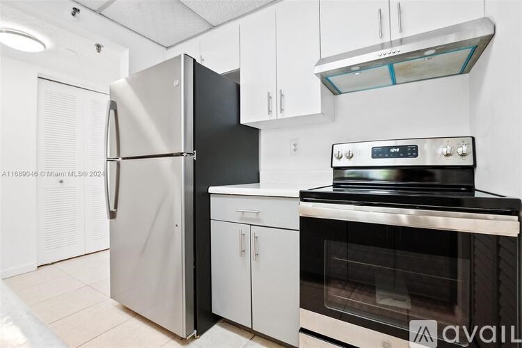 A kitchen with a stainless steel refrigerator, oven, and cabinets.