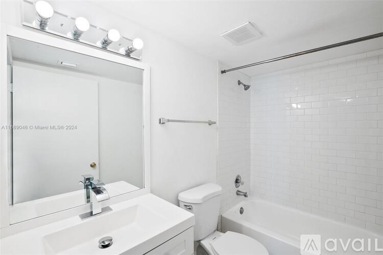 A white bathroom with a sink, toilet, and bathtub.