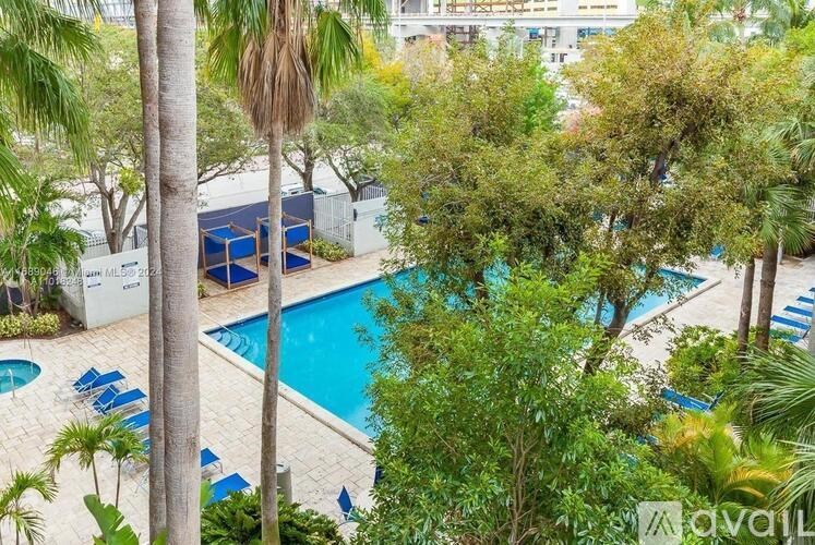 A pool surrounded by trees and palm fronds.