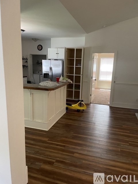 A kitchen with white cabinets and a wooden floor.