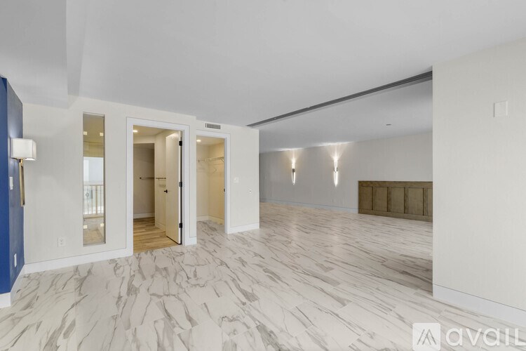 A spacious room with marble flooring and white walls.