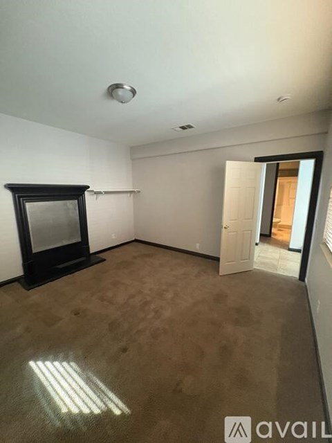 A room with a black fireplace and carpeted floor.