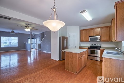A kitchen with wooden cabinets and a white island.