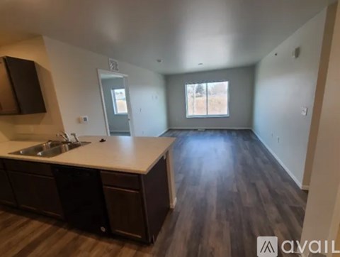 A kitchen with dark wood floors and a white countertop.