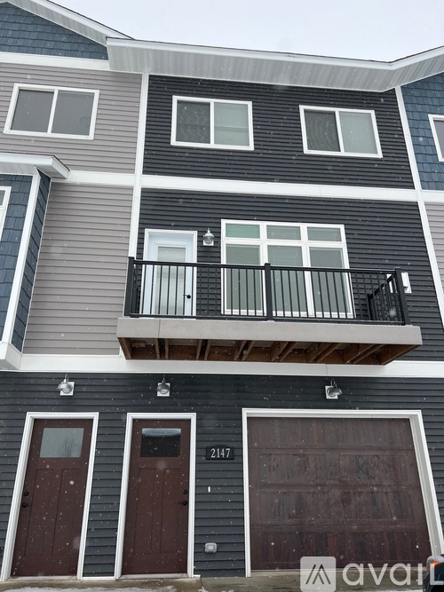 A two-story house with a balcony on the second floor.