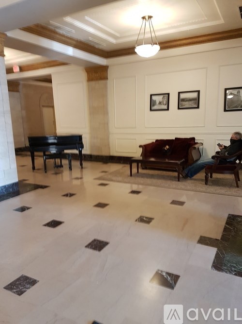 A man is sitting on a couch in a room with a piano.