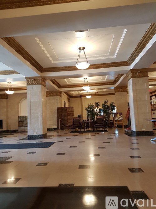 A large room with a marble floor and columns.