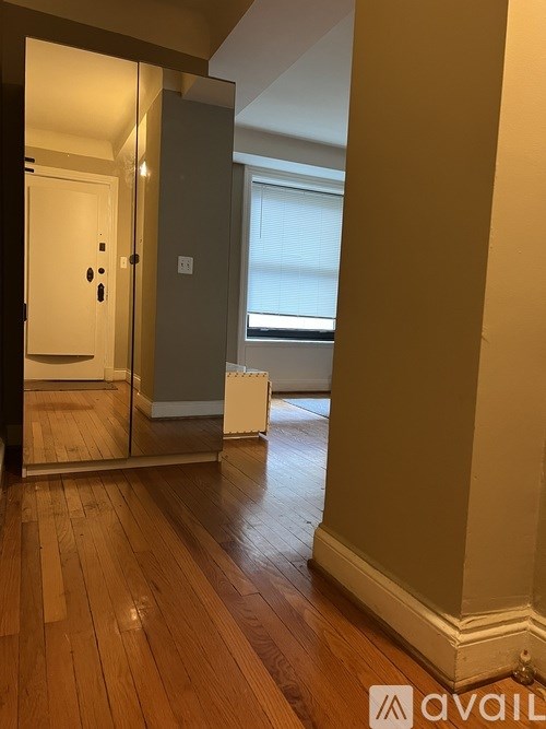 A room with wooden floors and a white column.