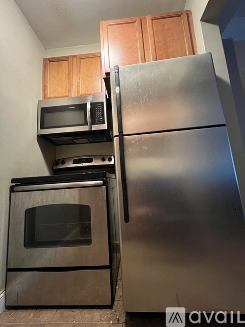 A kitchen with a stainless steel refrigerator, oven, and microwave.