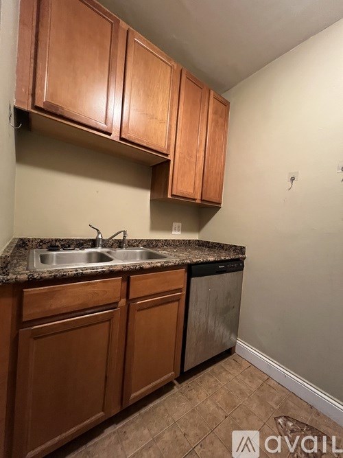 A kitchen with brown cabinets and a granite countertop.