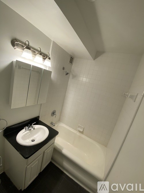 A bathroom with a sink, mirror, and bathtub.